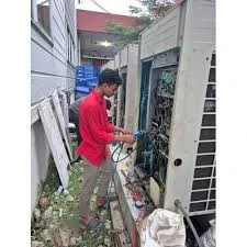 Technician inspecting a tall outdoor air conditioning system