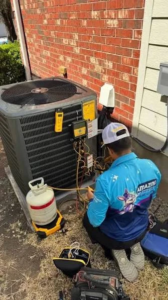 Technician servicing an outdoor residential air conditioner with diagnostic tools
